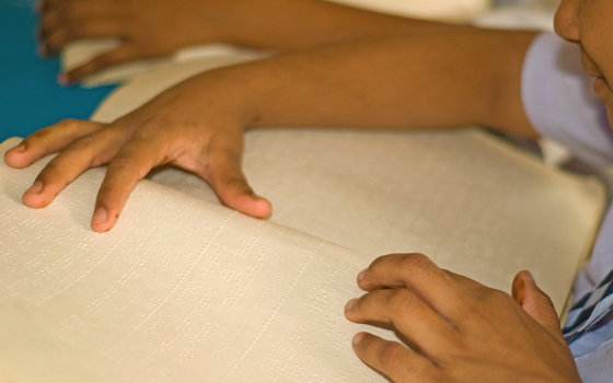 Foto di bambino che legge un testo in braille